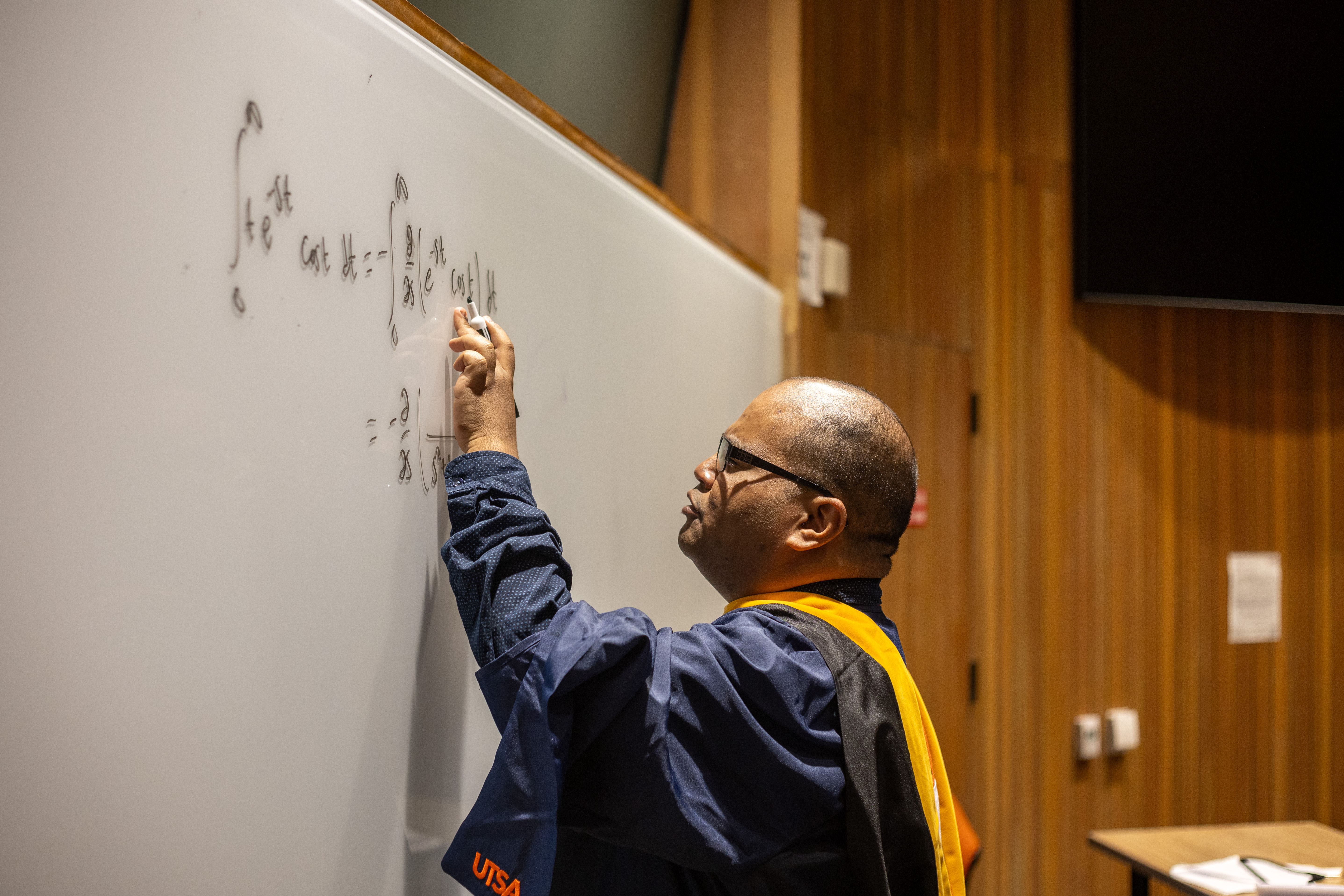 A photo of Roberson at the board evaluating a Laplace transform. Photo by Calvin Jessen; instagram.com/calvin.photos